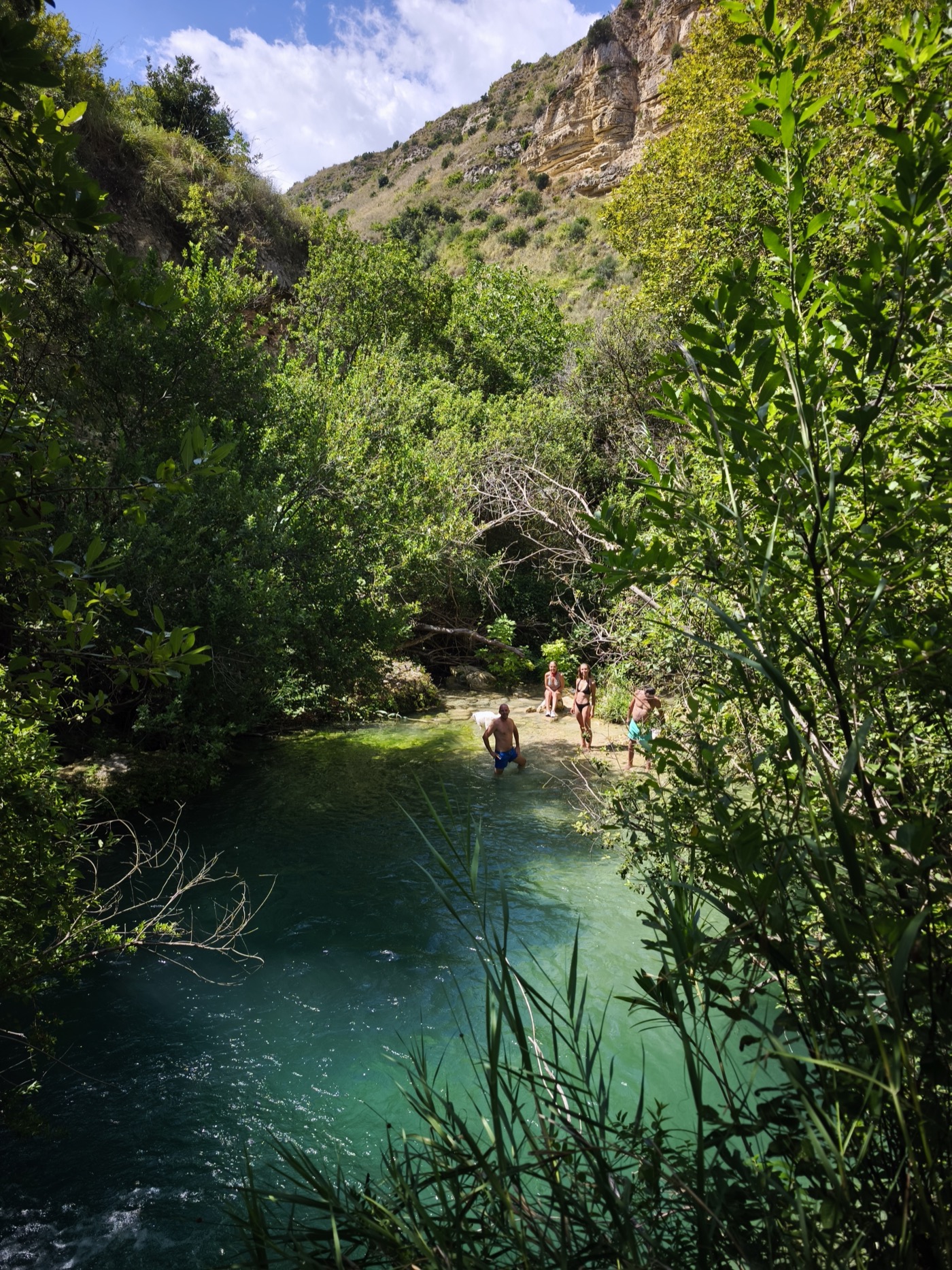 Swimmers in a natural rock pool at Cava Grande del Cassibile canyon, Sicily, in high summer