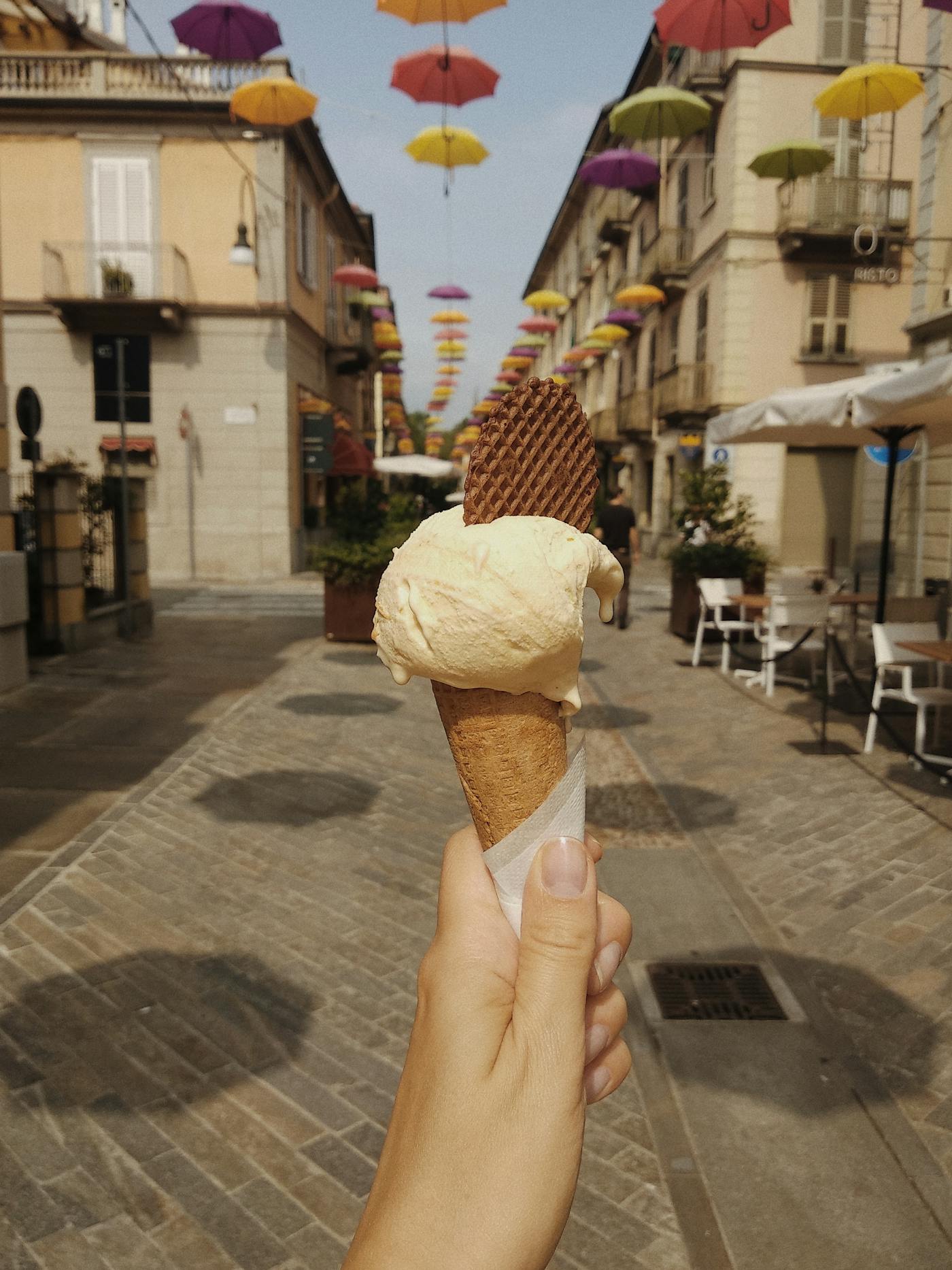 Main tenant un cornet de gelato italien dans une rue ensoleillee