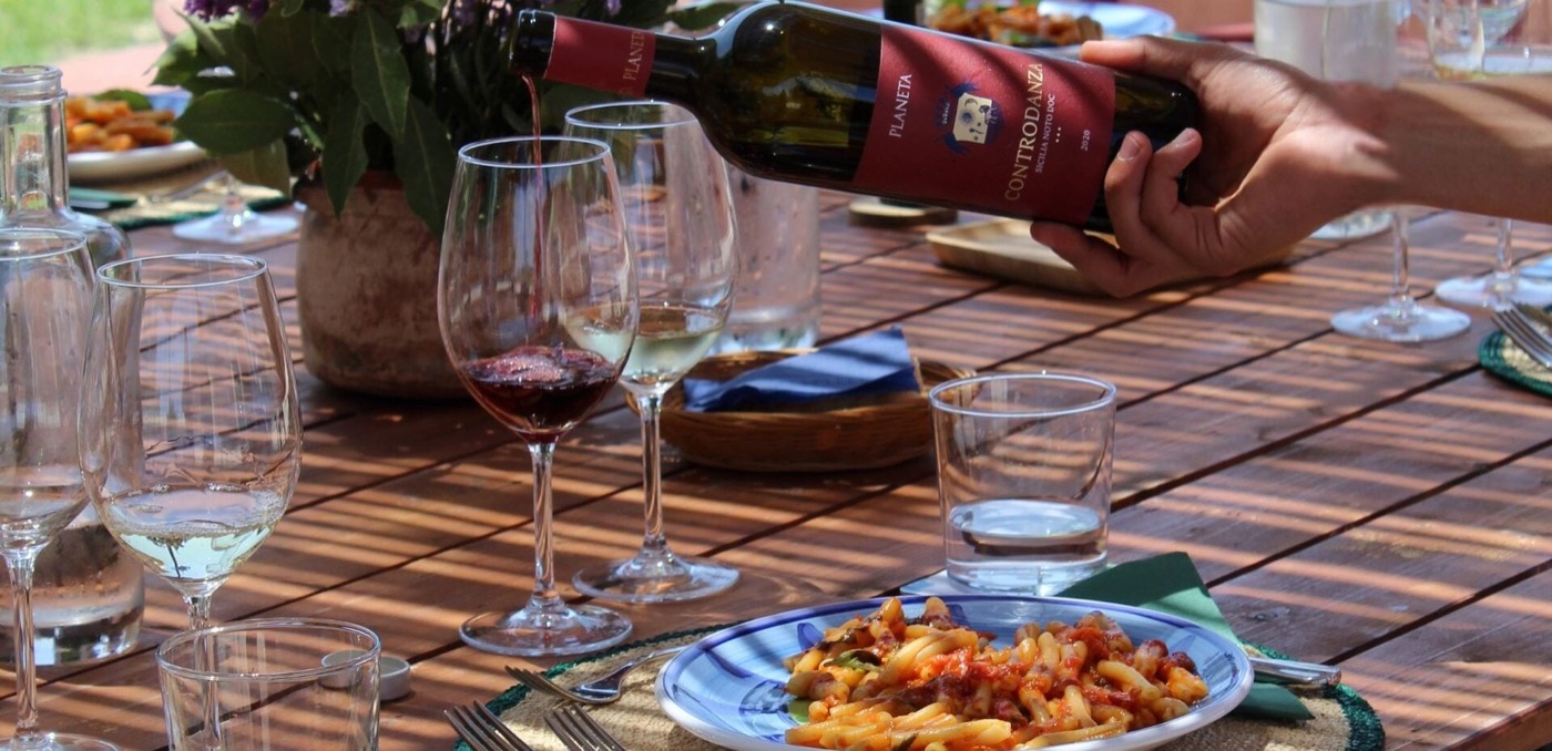 Dejeuner en longue table parmi les vignes d'un domaine de la Contrada Buonivini — vin, pain et plats siciliens