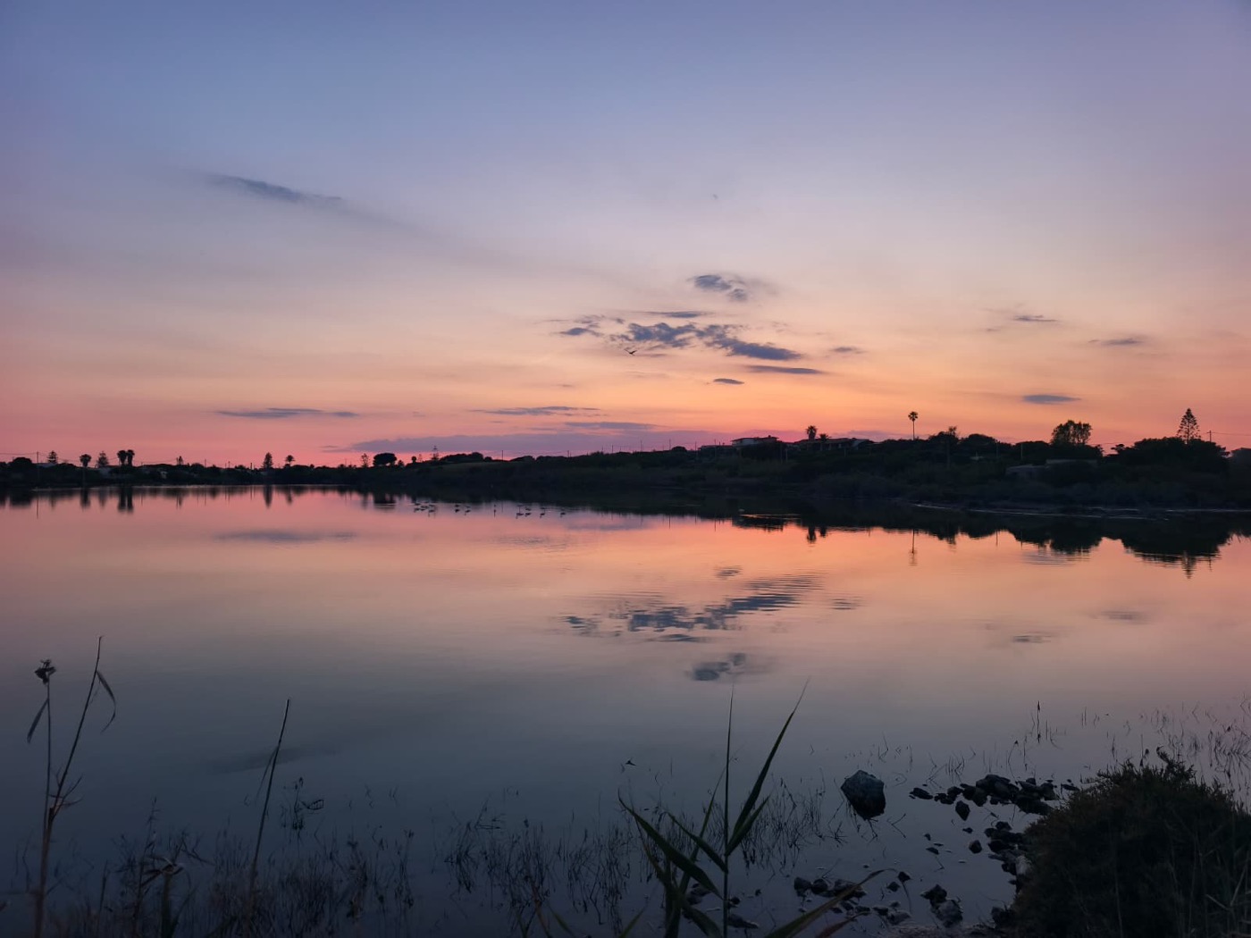 Coucher de soleil rose et bleu reflete dans les marais salants immobiles pres de Villa Magnus